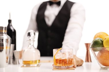 Barmen beyaz arka planda izole edilmiş buzlu viski servisi yapıyor.