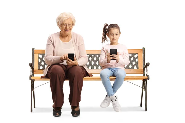 Criança Uma Mulher Idosa Sentadas Banco Digitando Telefones Celulares Isolados — Fotografia de Stock