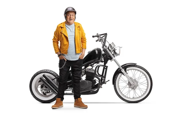 成熟したバイクでA黄色の革のジャケット笑顔とポージングとともにチョッパーバイク孤立した白の背景 — ストック写真