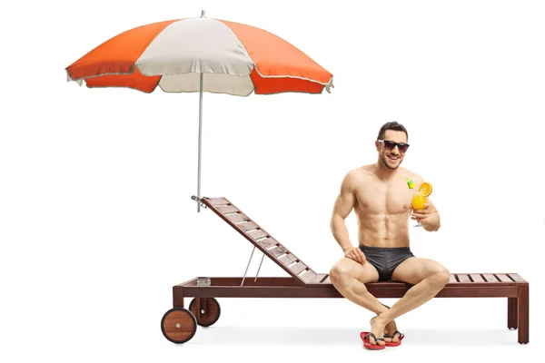 Fit Man Zittend Een Zonnebank Onder Paraplu Met Een Cocktail — Stockfoto