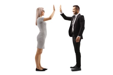 Beyaz arka planda soyutlanmış bir işadamıyla el kol hareketi yapan genç bir kadının tam boy profil çekimi.