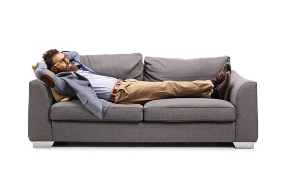满头胡须的男人躺在白色背景的灰色沙发上 — 图库照片