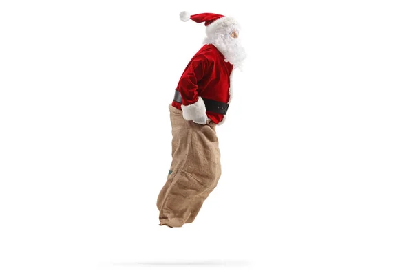 圣诞老人跳进一个用白色背包隔开的袋子里的侧面照片 — 图库照片