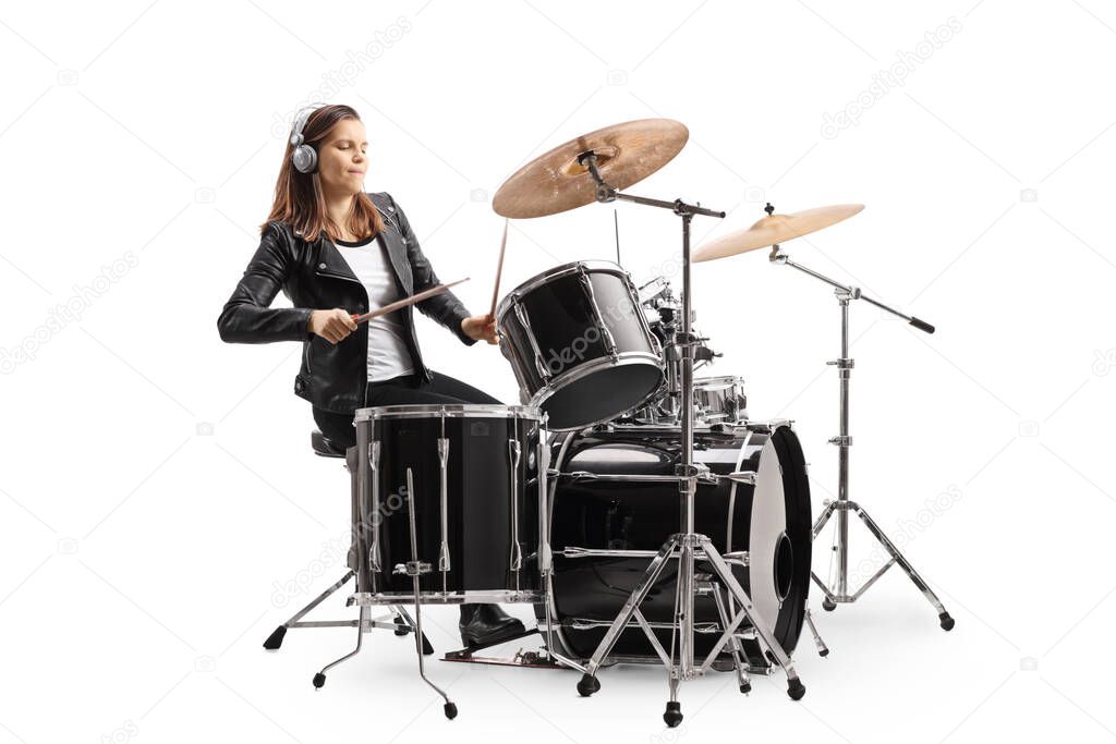 Young woman playing drums with headphones isolated on white background