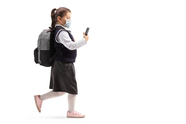 全长拍摄一个戴着防护面罩的女学生 她的手机在白色背景下独立行走 — 图库照片