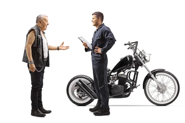 フル長いですショットのオートバイ整備士ととともにA成熟したバイクとともにチョッパー隔離された上の白い背景 — ストック写真