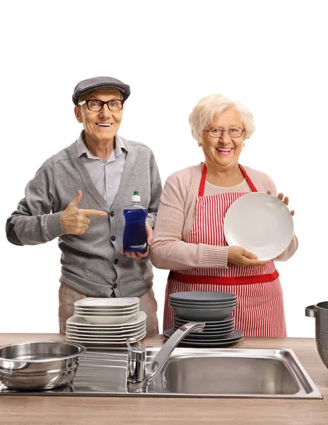 Elderly Couple Washing Dishes Togeather Showing Dishwashing Liquid Bottle Isolated — Stock Photo, Image
