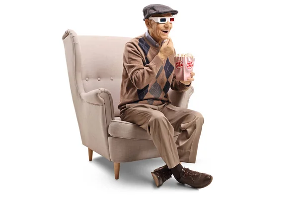 Oudere Man Een Fauteuil Eten Popcorn Geïsoleerd Witte Achtergrond — Stockfoto