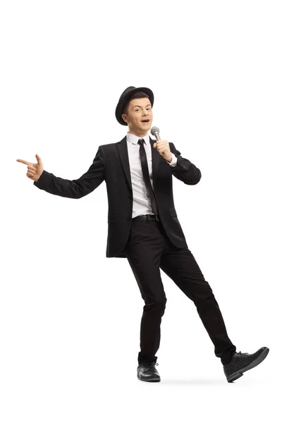 スーツと帽子の若い男の完全な長さの肖像ダンスと白の背景に隔離されたマイクで歌う — ストック写真