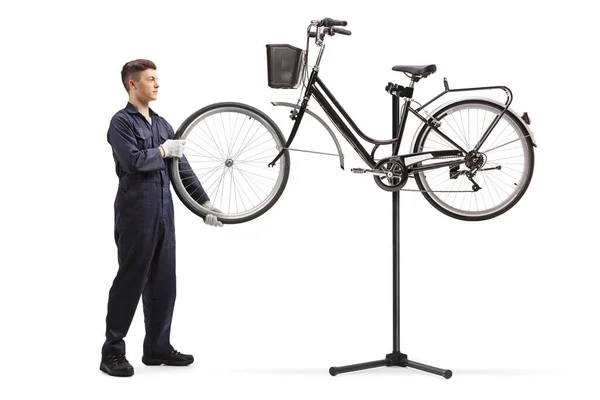 Веломеханик Ремонтирующий Колесо Велосипеда Висящее Ремонтном Стенде Изолированном Белом Фоне — стоковое фото