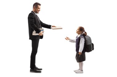 Bir adamın, beyaz arka planda izole edilmiş okul üniformalı küçük bir kıza kitap verirken tam boy profil fotoğrafı.