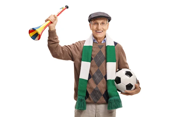 白い背景に孤立したカメラで笑顔サッカーボールとホーンを持つ高齢者の男 — ストック写真