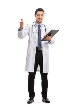 Beyaz arka planda parmak gösteren genç bir erkek doktorun tam boy portresi. 