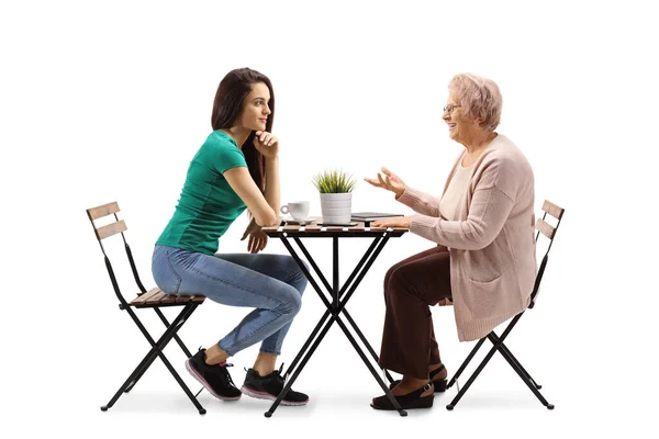 Mujer Joven Sentada Una Mesa Escuchando Una Anciana Hablando Aislada —  Fotos de Stock