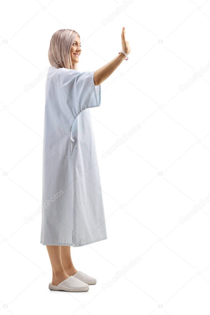 Full length profile shot of a female patient greeting with hand isolated on white background