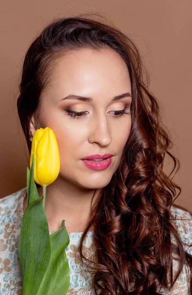 Young beautiful woman holding a bouquet of yellow tulips. Spring. — Stock Photo, Image