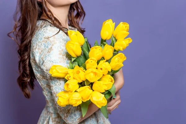 Молода красива жінка тримає букет жовтих тюльпанів. Весна . — стокове фото