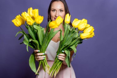 Bir buket Sarı laleler tutan genç güzel kadın. Bahar.