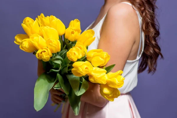 Молода красива жінка тримає букет жовтих тюльпанів. Весна . — стокове фото