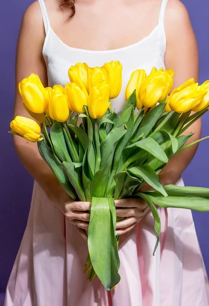Jovem mulher bonita segurando um buquê de tulipas amarelas. Primavera . — Fotografia de Stock