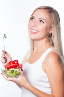 Genç güzel kadın sebze salatası yiyor. Sağlıklı beslenme. Şeklinde olmak.