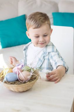 Sevimli küçük çocuk Paskalya yumurtaları ve Paskalya tavşanı ile oynuyor. Tatil. Bahar.