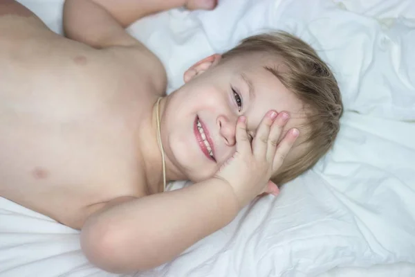 Portrét roztomilý chlapeček šťastný. Babe blázni v posteli. — Stock fotografie