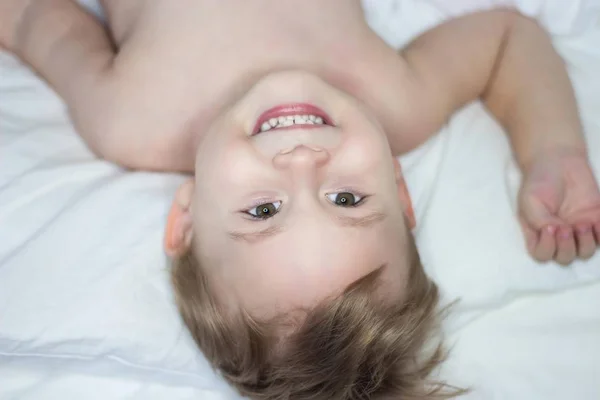 Πορτρέτο του ένα χαριτωμένο μικρό ευτυχισμένο αγόρι. Μωρό ανόητοι στο κρεβάτι. — Φωτογραφία Αρχείου