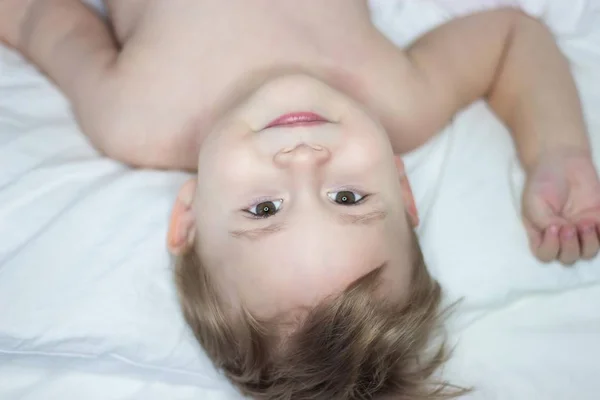Πορτρέτο του ένα χαριτωμένο μικρό ευτυχισμένο αγόρι. Μωρό ανόητοι στο κρεβάτι. — Φωτογραφία Αρχείου