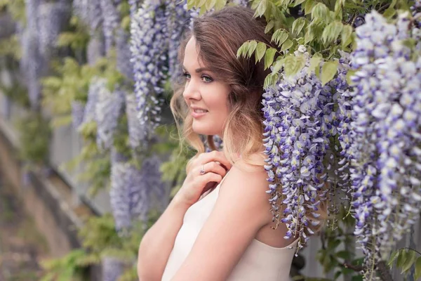 Wisteria. Portret młodej kobiety piękne w pobliżu kwiaty bzu. Ciepłe wiosny. — Zdjęcie stockowe