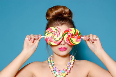 Mavi bir arka plan üzerinde şeker ile güzel bir genç kadın portresi. Sarışın renkli şeker ile. Tatlı. Parlak kadınla