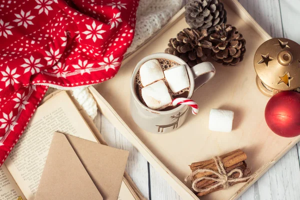 Humor de Natal. Café da manhã aconchegante. Xadrez, uma bandeja, uma caneca de cacau quente, marshmallows. O livro e o cartão de Natal . — Fotografia de Stock