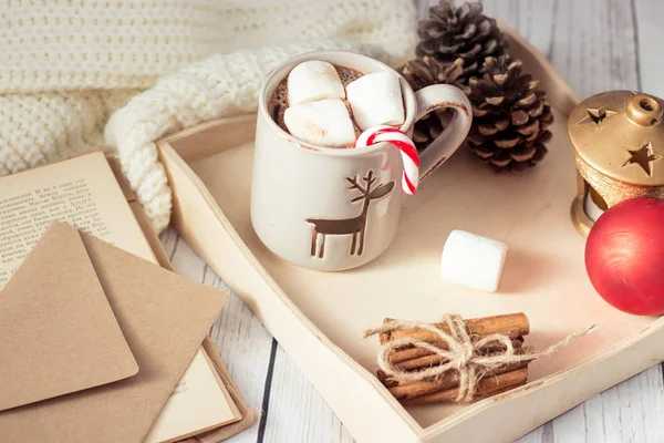 Humor de Natal. Café da manhã aconchegante. Xadrez, uma bandeja, uma caneca de cacau quente, marshmallows. O livro e o cartão de Natal . — Fotografia de Stock