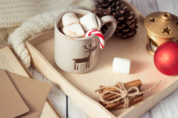 Weihnachtsstimmung. Gemütliches Weihnachtsfrühstück. Plaid, ein Tablett, ein Becher heißen Kakao, Marshmallows. das Buch und die Weihnachtskarte. — Stockfoto