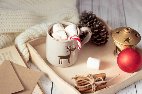 Weihnachtsstimmung. Gemütliches Weihnachtsfrühstück. Plaid, ein Tablett, ein Becher heißen Kakao, Marshmallows. das Buch und die Weihnachtskarte. — Stockfoto