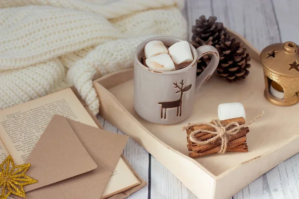 Weihnachtsstimmung. Gemütliches Weihnachtsfrühstück. Plaid, ein Tablett, ein Becher heißen Kakao, Marshmallows. das Buch und die Weihnachtskarte. — Stockfoto