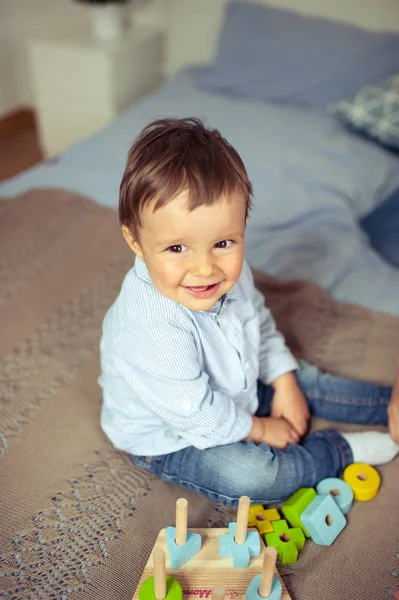 Jongetje speelt op het bed. Een gelukkig klein kind. — Stockfoto