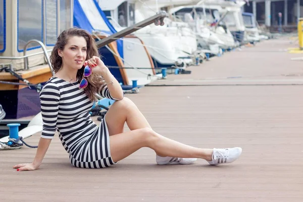 Mooie jonge vrouw in de buurt van de jachten. Portret van een jonge sexy vrouw. Mooie gebruinde vrouw in vest, zomer zee vakantie. Happ — Stockfoto