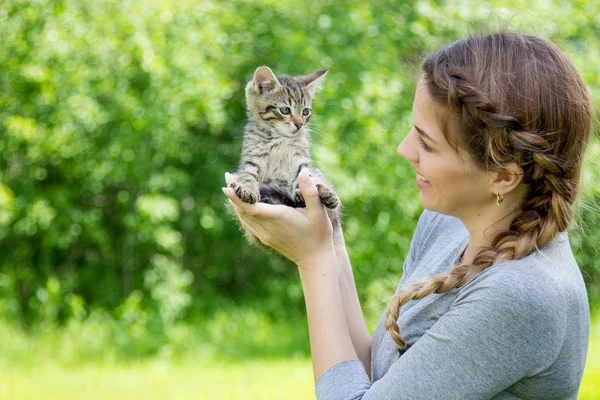 Retrato de una joven hermosa mujer y gatito. Una chica sosteniendo un gatito . — Foto de Stock