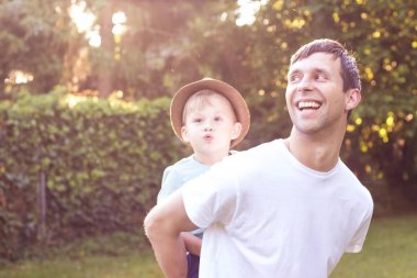 Baba ve oğul günbatımında yürümek. Mutlu baba ve oğlunun güneşin.
