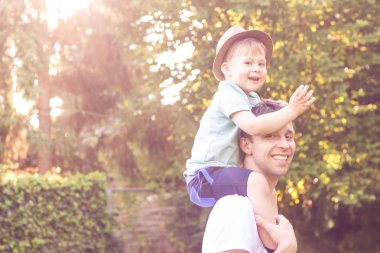 Baba ve oğul günbatımında yürümek. Mutlu baba ve oğlunun güneşin.