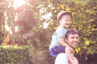 Baba ve oğul günbatımında yürümek. Mutlu baba ve oğlunun güneşin.