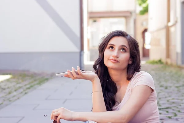 Jovem bela mulher morena caminha na cidade na Europa. Verão. Menina feliz. Moda de rua. Jovem mulher bonita fala por telefone. A menina tira fotos de si mesma . — Fotografia de Stock