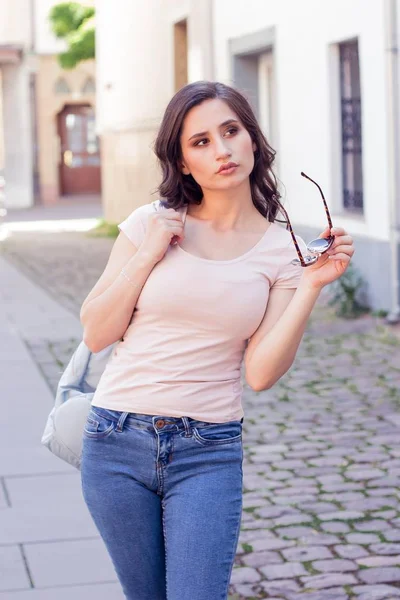 Jeune belle femme brune se promène à la ville en Europe. L'été. Bonne fille. Mode de rue . — Photo