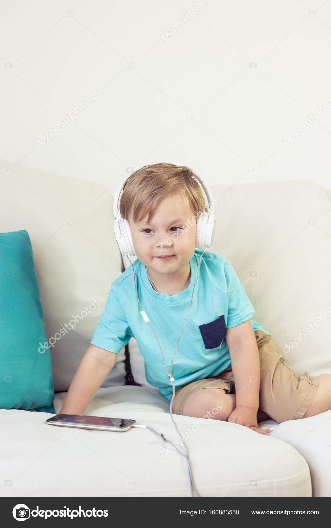 photo Cute 3 Year Olds Boys 3 year old boy sits on the couch and listens to music little cute boy watching cartoons on the phone little boy stock photo image by c karelia89 160883530