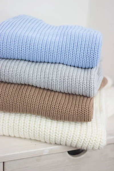 Une pile de vêtements chauds d'automne sur une étagère en bois. Des pulls. Vêtements d'hiver tricotés. Confortable . — Photo
