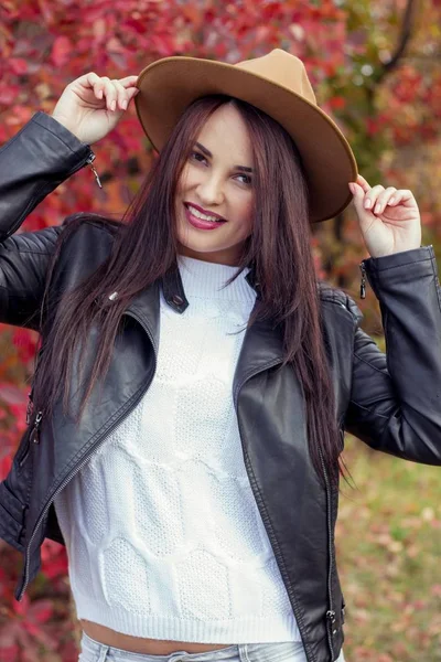 年轻漂亮的女人的帽子和外套在秋天的公园。温暖的秋天。秋季幅画像，一个快乐的女孩。幸福的年轻女人走 — 图库照片