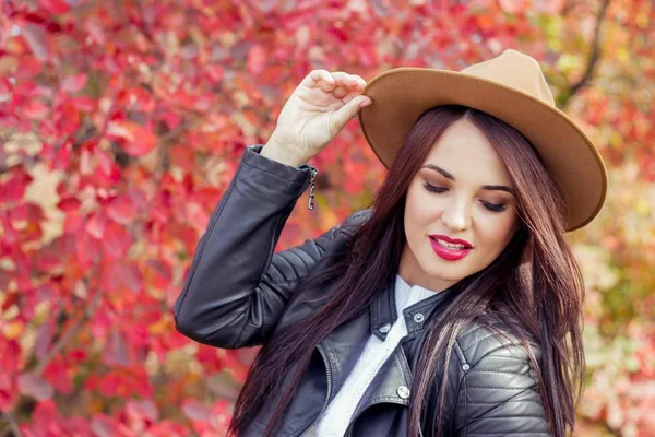 Ung vacker kvinna i en hatt och jackan i höst park. Varm höst. Hösten porträtt av en glad tjej. Glad ung kvinna walkin — Stockfoto