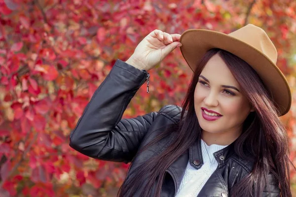 年轻漂亮的女人的帽子和外套在秋天的公园。温暖的秋天。秋季幅画像，一个快乐的女孩。幸福的年轻女人走 — 图库照片