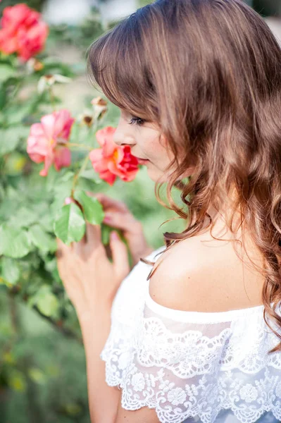 Genç güzel kadın çiçekli parkta yürüyor. Genç bir kadın portresi. Mutlu kız. Yaz.